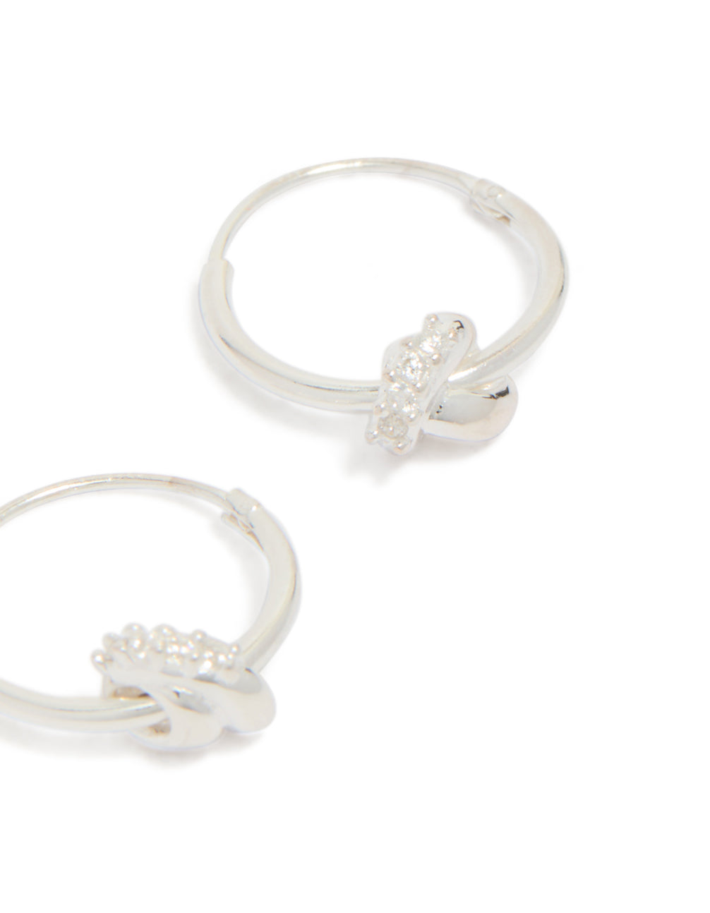 Featuring sterling silver cubic zirconia knotted hoop earrings with detailed craftsmanship in close up view