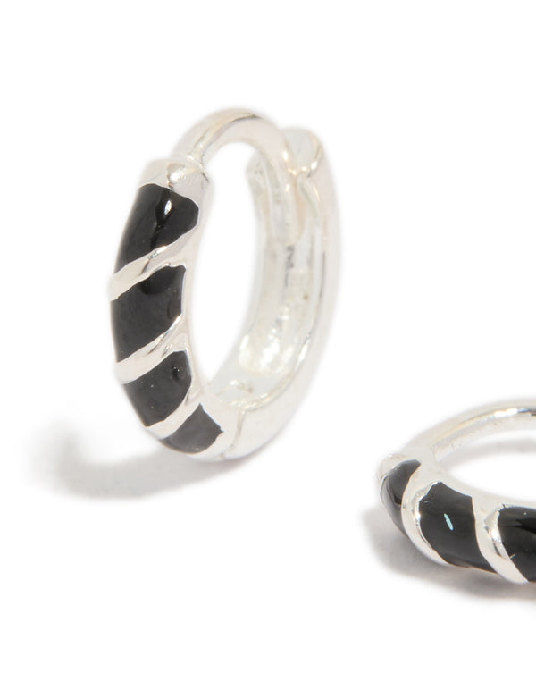 Crafted from sterling silver, these black striped enamel huggie earrings feature hoop closure close up view