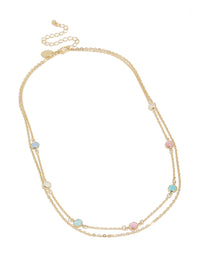 Beautiful gold plated layered necklace with pink and blue stones details in a statement style front view - link has visual effect only