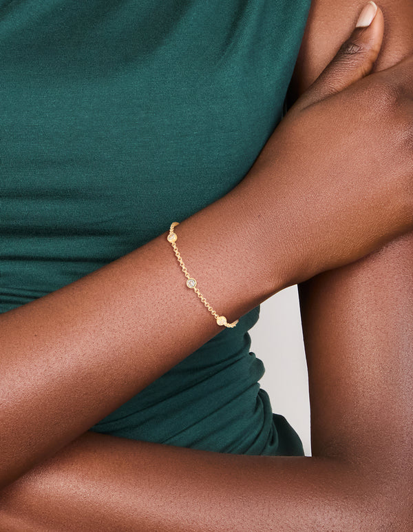 Showcasing a gold plated cubic zirconia bezel set bracelet on wrist view