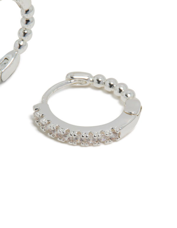 Skinny huggie earrings crafted from silver plated material with cubic zirconia and hoop closure post detail view