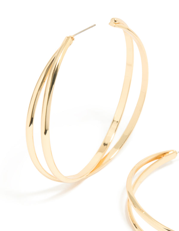 Featuring large crossover hoop earrings in gold with elegant design close up view