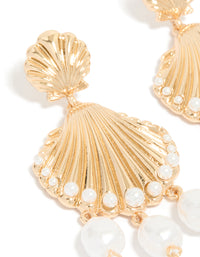 Detailed gold ribbed shell and pearls charm drop earrings with ocean theme in statement style close up view - link has visual effect only