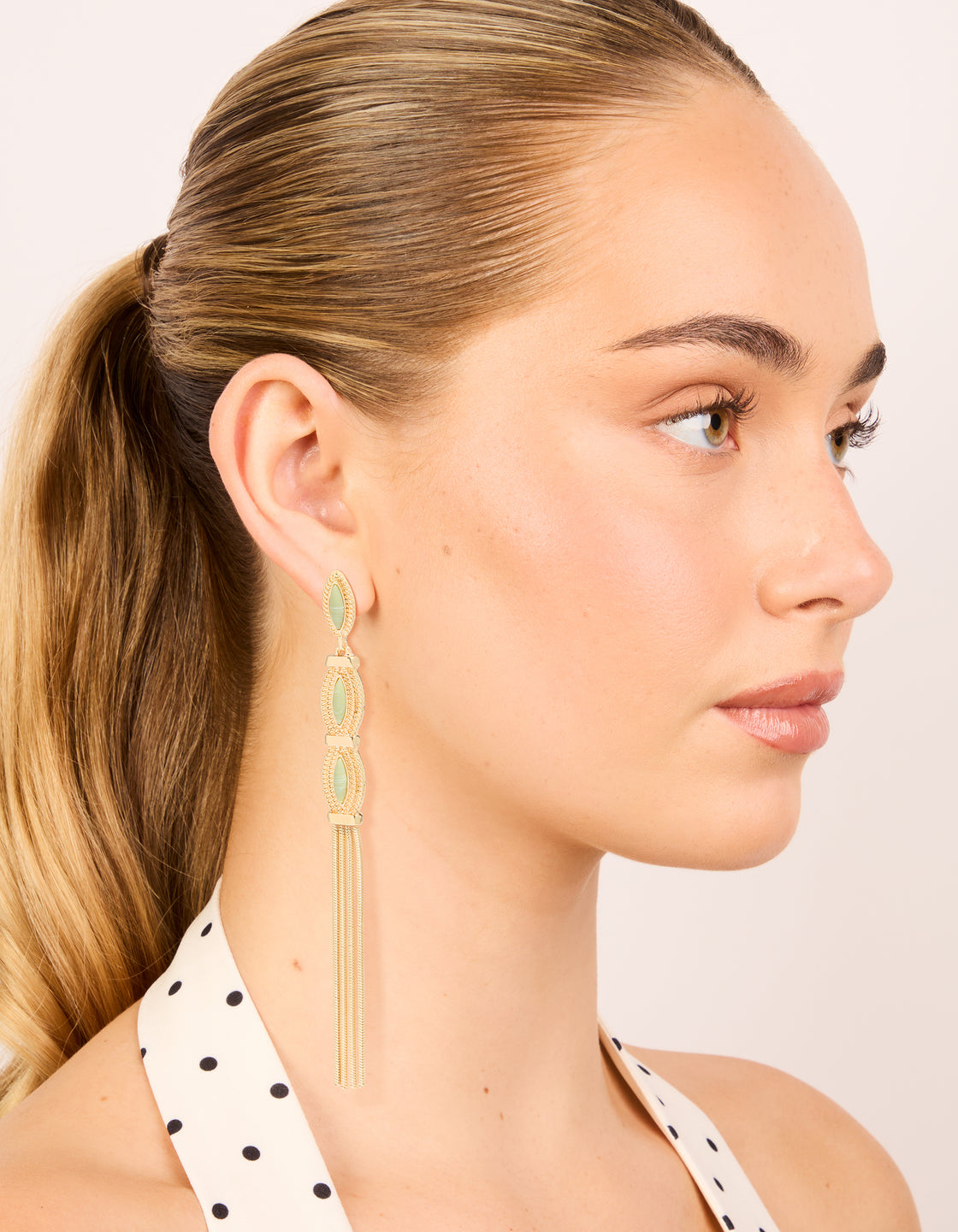 Elegant gold green stone boho tassel drop earrings with statement design on model view