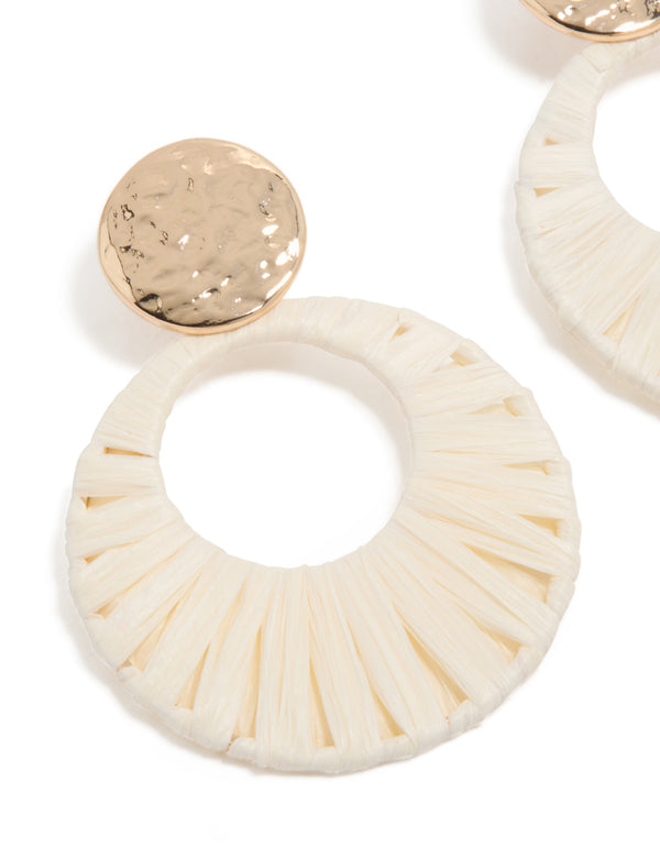 Featuring statement drop earrings with gold hammered studs and white raffia paper circle drops in ivory and wheat tones close up view