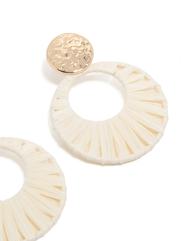Crafted with gold hammered studs and white raffia paper circle drops in ivory and wheat tones, these statement earrings post detail view