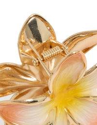 Highlighting the floral enamel peach and yellow frangipani claw clip in gold detail view - link has visual effect only