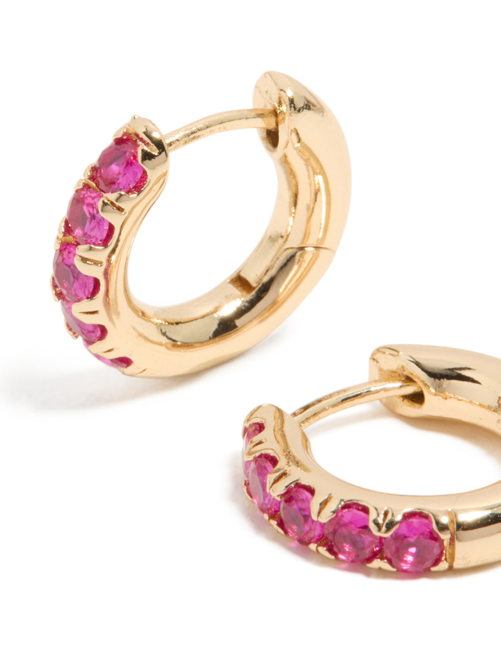 Showcasing small statement huggie clicker earrings featuring cubic zirconia in gold and hot pink close up view