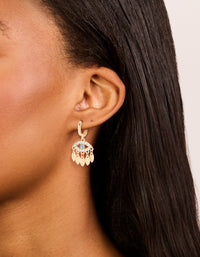 Showcasing statement huggie earrings featuring evil eye charm accents in gold on ear view - link has visual effect only