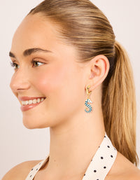 Highlighting gold hoop earrings with teal and white seahorse featuring ocean-inspired details on model view - link has visual effect only