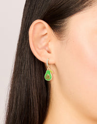 Showcasing gold diamante avocado huggie earrings featuring a fruit design in lime green enamel, on ear view - link has visual effect only