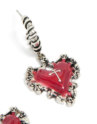 Capturing ornate detailing of statement huggie earrings with crimson heart and gothic cross in silver post detail view - link has visual effect only