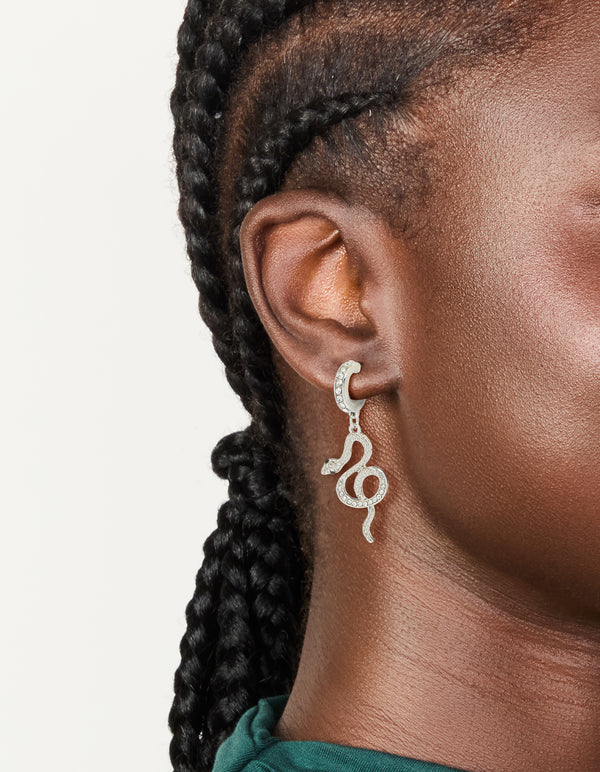 Showcasing silver diamante snake huggie earrings in statement style on ear view
