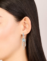 Showcasing silver diamante dreamcatcher huggie earrings with charm and feather detail accents in light blue, pink, and teal, on ear view - link has visual effect only