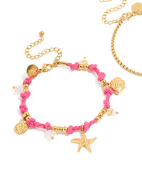 Featuring waterproof gold plated stainless steel cord bracelets in a 2-pack with ocean charms, beads, rose quartz and freshwater pearl details in pink and white close up view - link has visual effect only