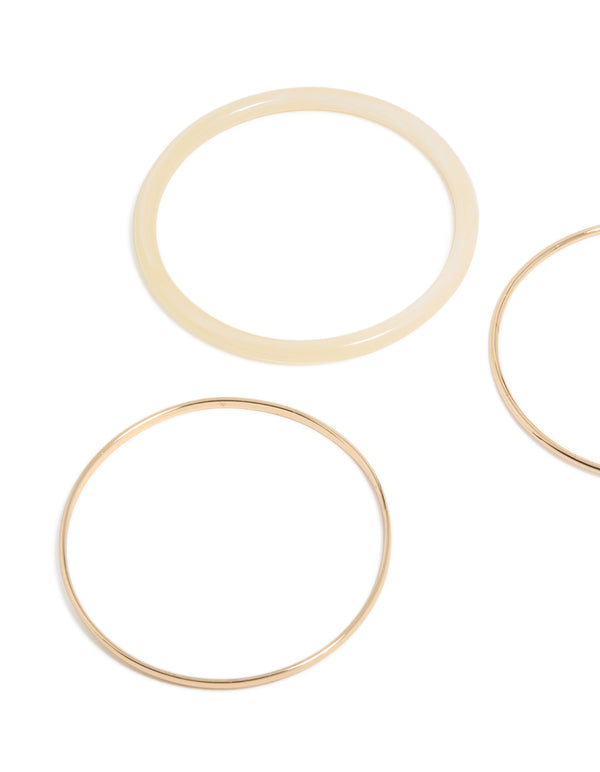 Featuring simple acrylic bangle in a 3-pack with gold and beige tones close up view