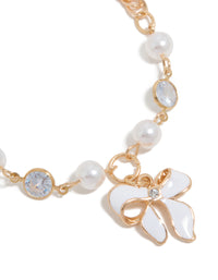 Featuring a gold statement bracelet with bow charm and pearl details close up view - link has visual effect only