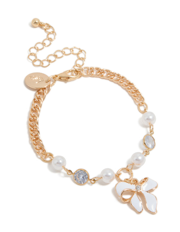 Crafted from gold with bow charm and pearl features in a statement bracelet front view