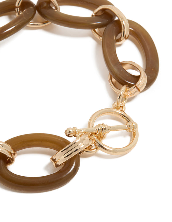 Highlighting a brown acrylic bracelet with gold accents, designed with detailed T-bar closure view