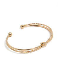 Showcasing a gold textured and smooth knotted wrist cuff bangle front view - link has visual effect only