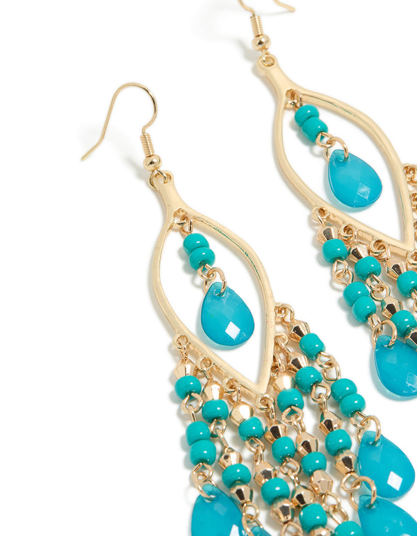 Elegant gold blue beaded oval fish hook drop earrings with charm and turquoise accents close up view