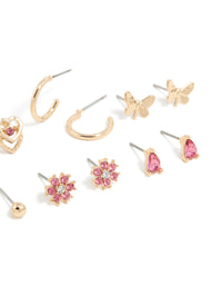 Crafted from gold with hot pink diamante, this stud earrings 7-pack showcases balls, floral, butterfly, and heart designs post detail view - link has visual effect only