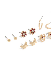 Explore stud earrings in a 7-pack with butterfly, floral, heart, and ball details featuring gold finish and red diamante accents close up view - link has visual effect only