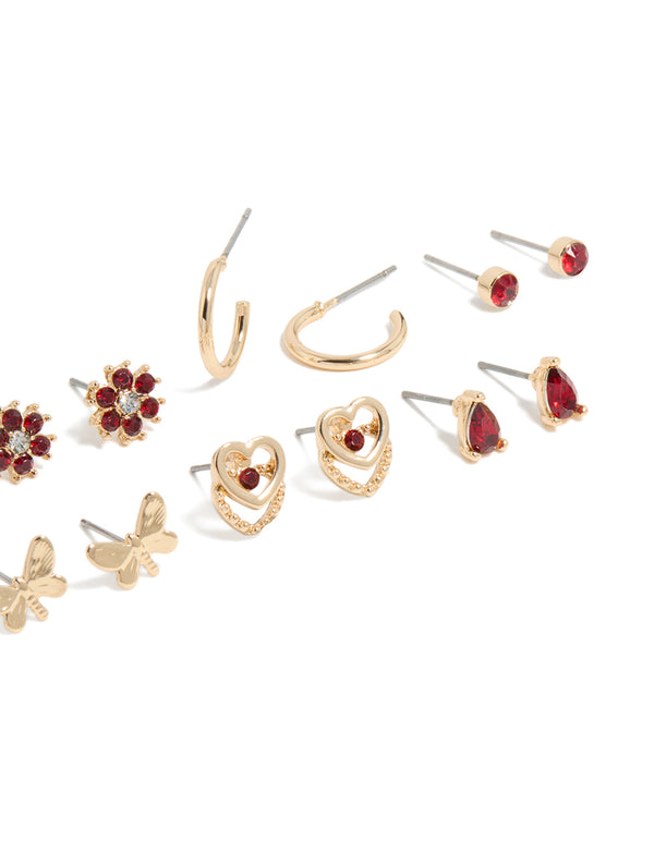 Shop stud earrings in a 7-pack featuring butterfly, floral, heart, and ball accents with gold finish and red diamante details post detail view