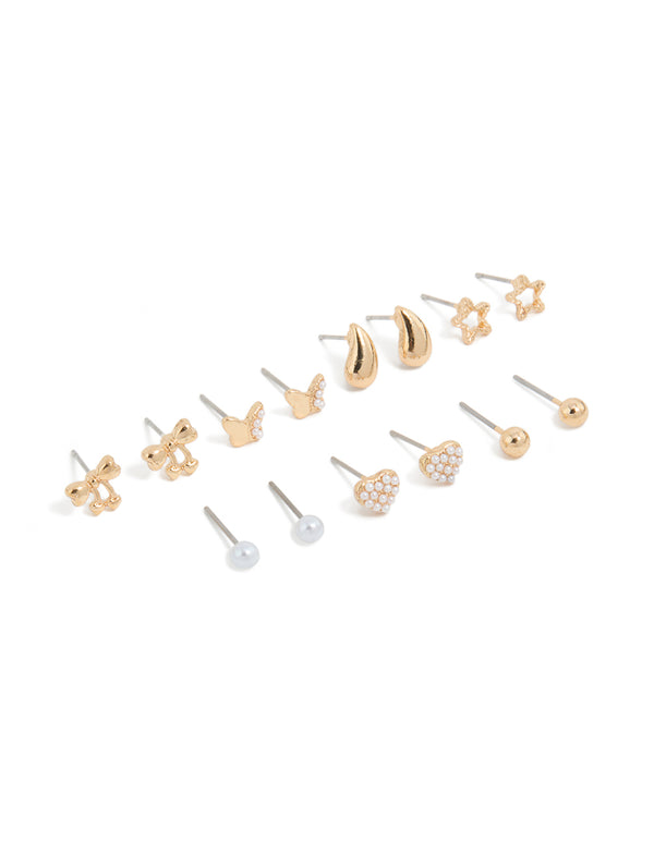 Featuring mini stud earrings in a 7-pack with bow, celestial star, ball, heart, and pearl designs in gold front view