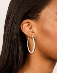 Showcasing silver plated dome hoop earrings with closure in silver on ear view - link has visual effect only