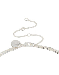 Showcasing silver plated bar and cross layered necklace with balls, beads designed in dainty style clasp detail view - link has visual effect only