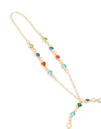 Beautifully crafted statement hand chain in multicolor diamantes featuring green, red, and blue stones close up view - link has visual effect only