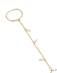 Showcasing a gold plated mini freshwater pearl droplet hand chain with charm in dainty statement style close up view - link has visual effect only