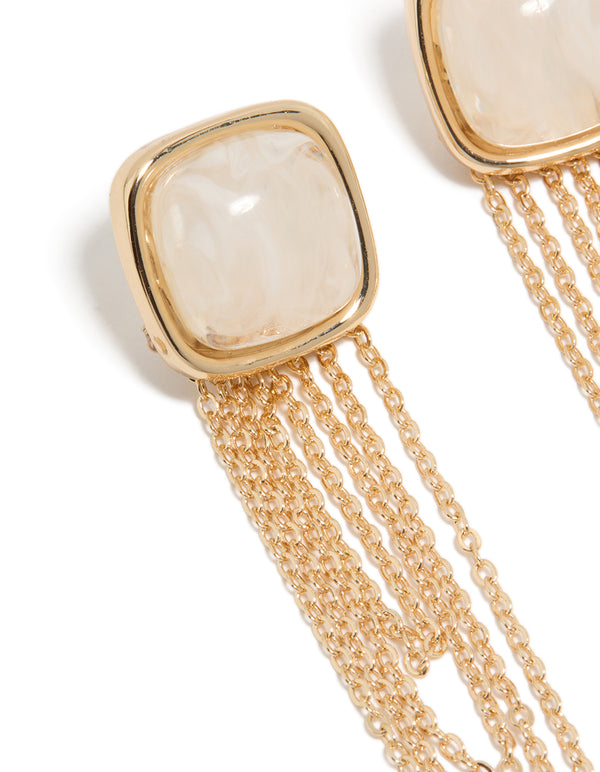Showcasing statement gold white stone and layered chain drop earrings close up view