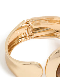Highlighting a gold teardrop brown stone wrist cuff in statement style closure detail view - link has visual effect only