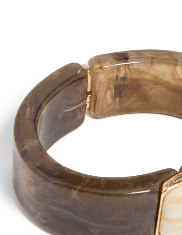 Highlighting the hinged fastening mechanism of this chunky brown and white acrylic square wrist cuff in tan, beige, and gold closure detail view
