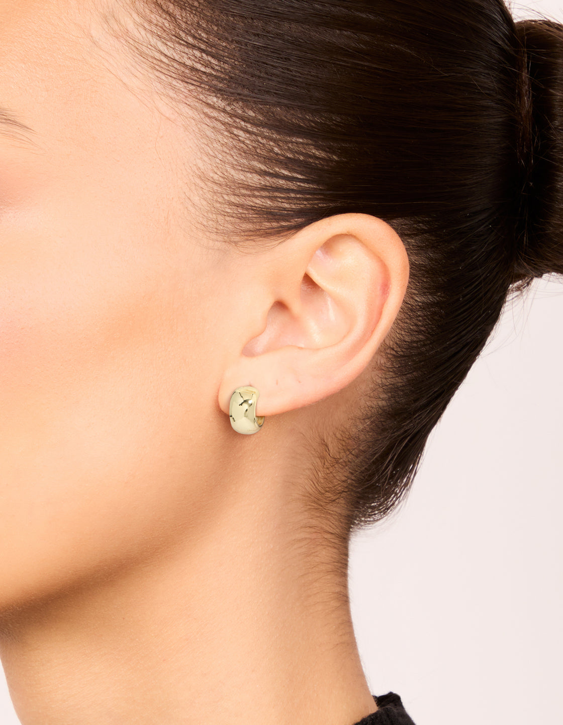 Design spotlight on small round open hoop earrings in a 3-pack with mixed metal plated finish featuring gold and silver tones on ear view