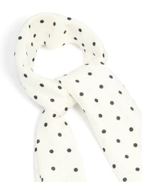 Displaying a polkadot fabric scarf in white and black detail view - link has visual effect only