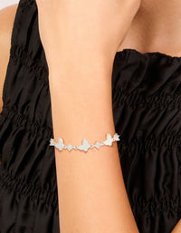 Featuring a silver plated toggle bracelet with smooth butterfly charms and cubic zirconia inlay on wrist view - link has visual effect only