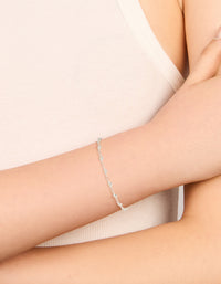 Featuring a silver plated cubic zirconia round dainty chain bracelet on wrist view - link has visual effect only