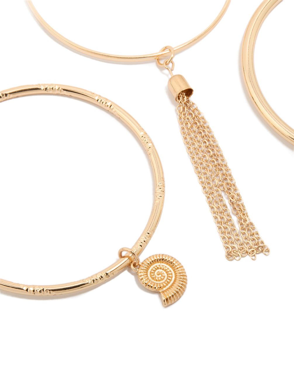 Detailed view of gold charm and tassel bangles in a 3-pack with shell and ocean-inspired details close up view