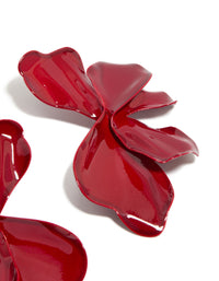 Crafted with large statement stud earrings showcasing floral petal design in red coated metal detail view - link has visual effect only