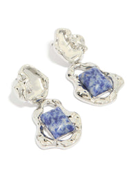 Showcasing silver molten semi precious stone drop earrings featuring blue gemstones in an organic textured setting front view - link has visual effect only