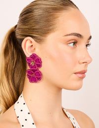 Crafted from hot pink fabric with beaded double flower drop earrings featuring statement design and gold accents on model view - link has visual effect only
