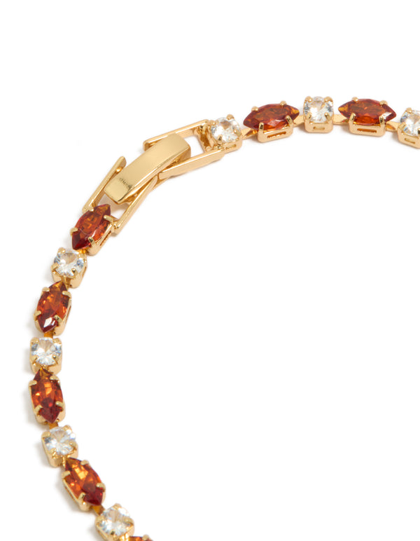 Displaying a gold plated tennis bracelet with clear and cognac cubic zirconia in multi cut closure detail view