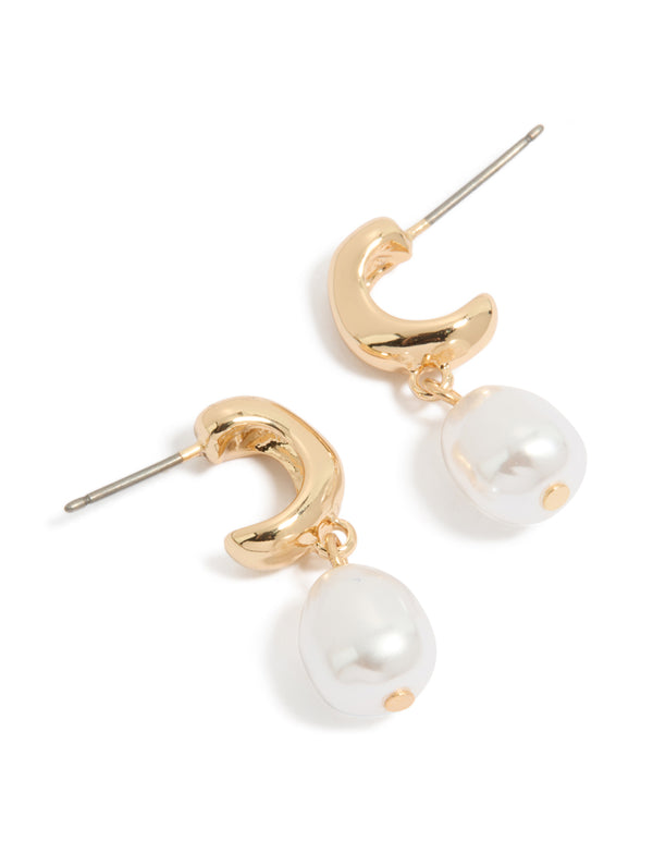 Showcasing gold pearl drop huggie earrings with huggie closure front view