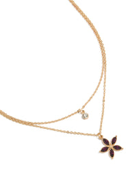 Showcasing a gold layered necklace with clear and purple diamante floral pendant close up view - link has visual effect only