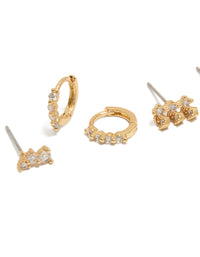 Featuring dainty gold plated cubic zirconia trio studs and huggie earrings in a 3-pack close up view - link has visual effect only