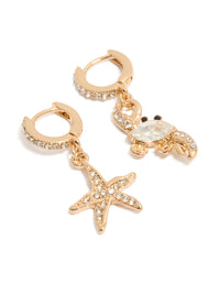 Showcasing mismatched huggie earrings in gold featuring ocean-themed motifs with crystal accents front view - link has visual effect only