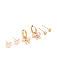 Showcasing gold plated stainless steel earrings featuring pink enamel bow and heart and ball with stud and huggie closures in a 3-pack front view - link has visual effect only